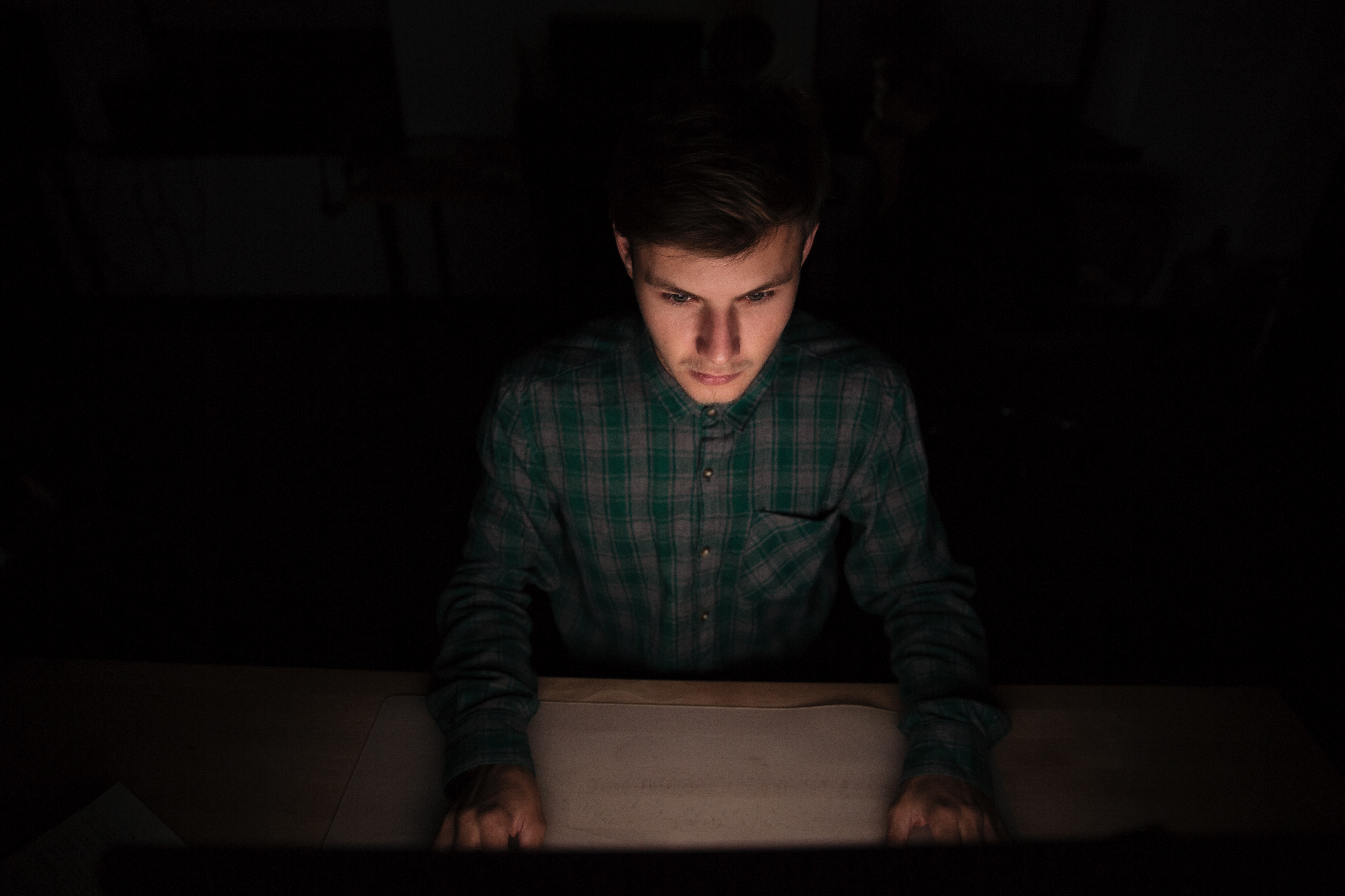 generic images of young man using computer in dark room