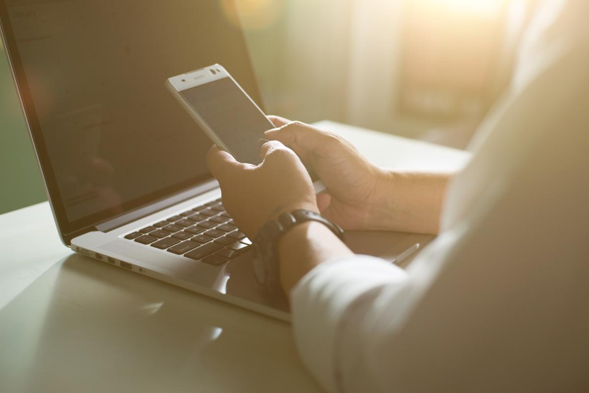 man with phone and laptop