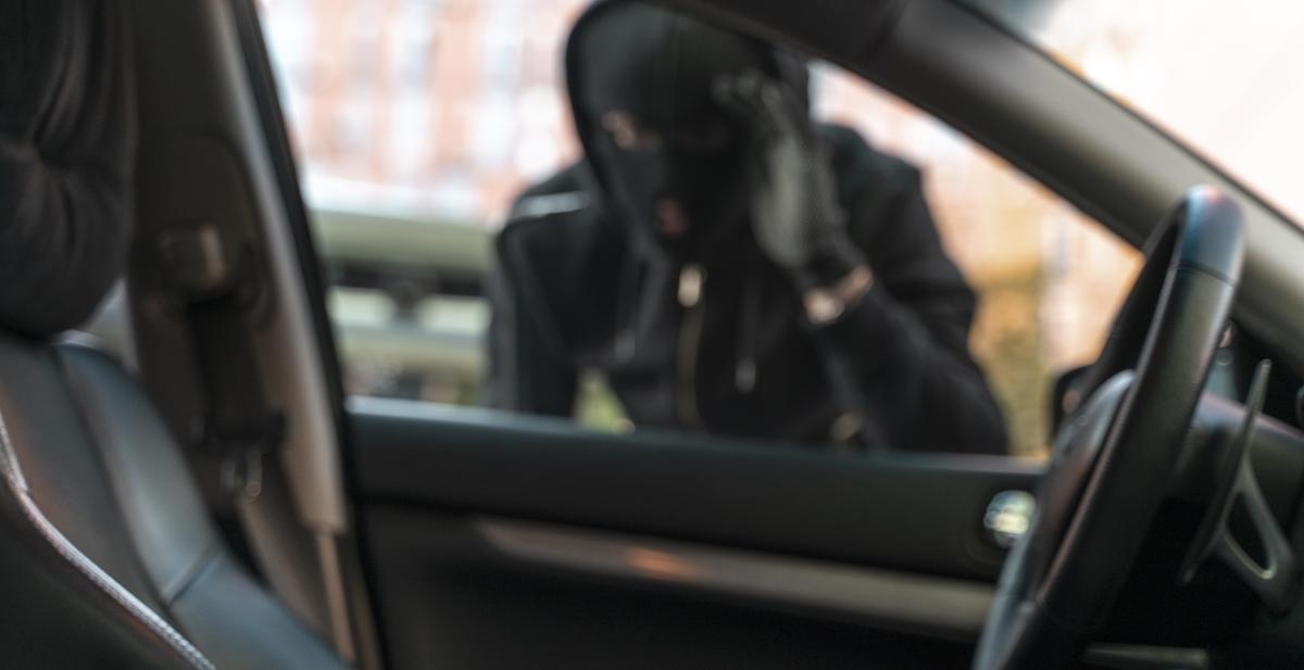 blurred image of criminal looking into car window